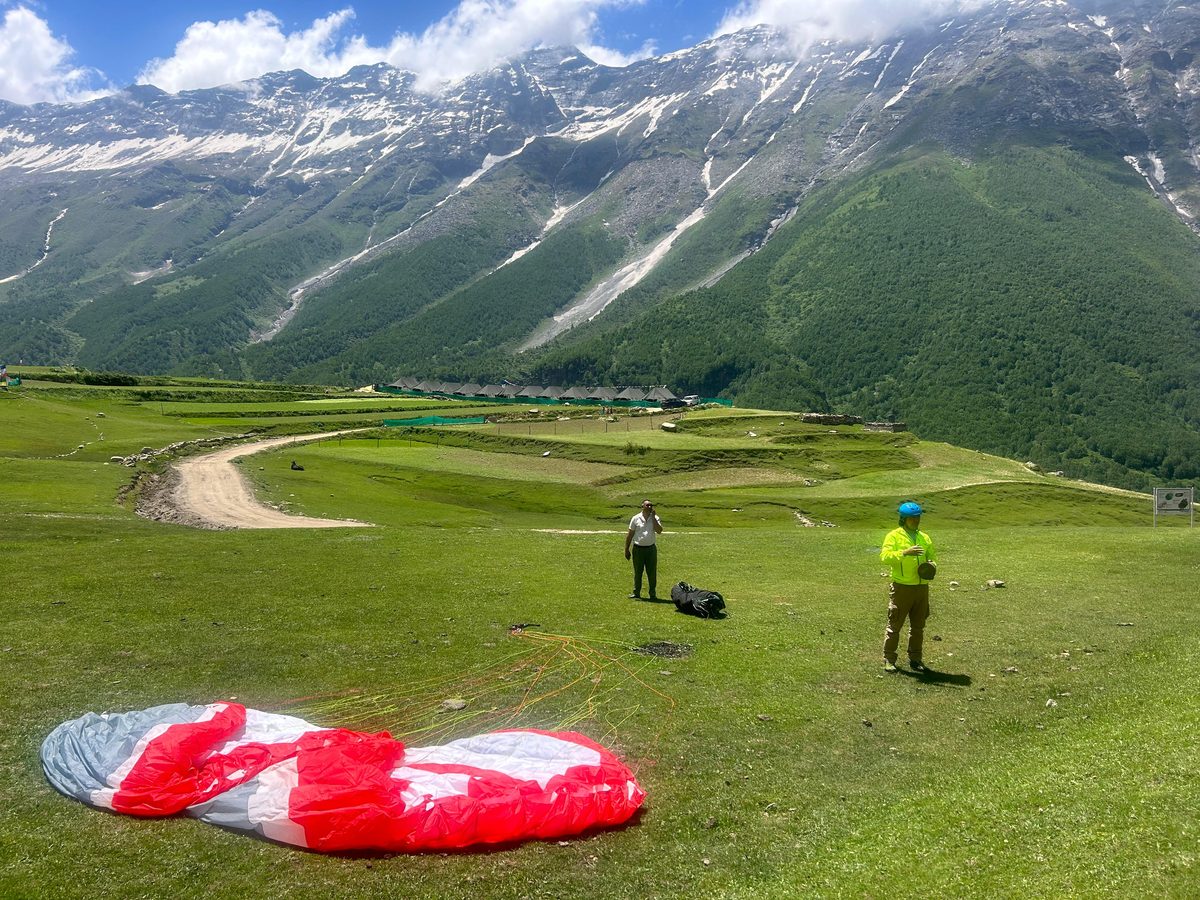 Paragliding setup in a Pangi Valley meadow